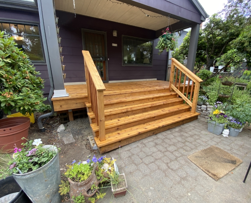 A newly remodeled cedar deck with wide steps leading up.